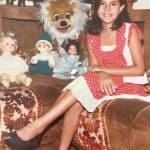 Rosmary WEISS als Kind im Jahr 1980 – ein Blick in die lebensfrohe Kindheit mit Puppen, Farben und Lächeln